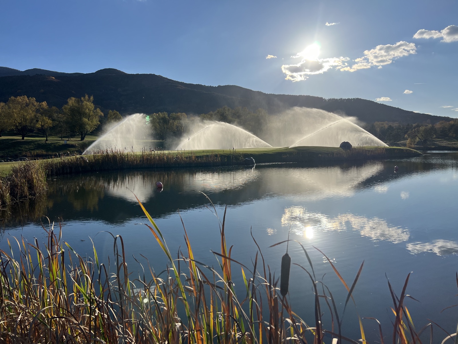 Sprinklers arcing over the lake at sunset