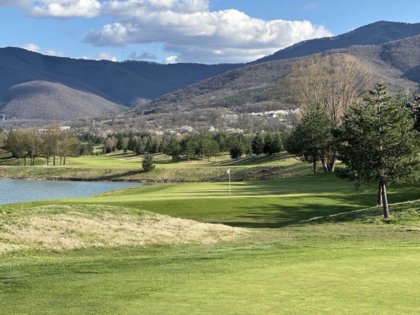 Pravets Golf Club — green by the lake with the Balkan mountains behind