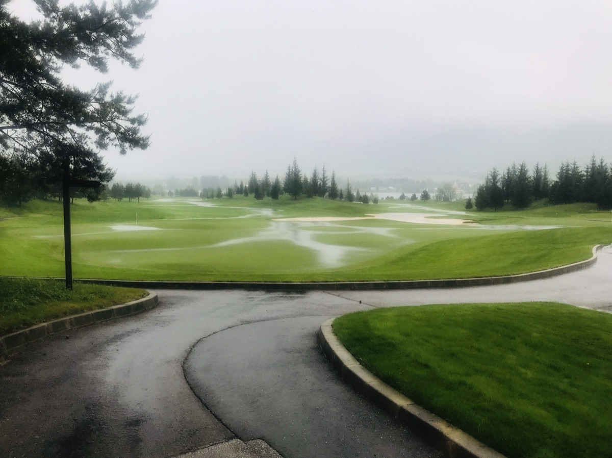 Rain-soaked course with standing water around the bunkers